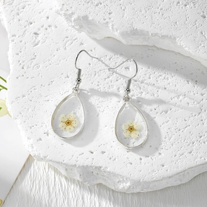 Vue détaillée de boucles d'oreilles en argent avec fleurs séchées jaunes en résine