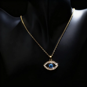 Gold Evil Eye necklace with blue stone and rhinestone pave on a black neck display