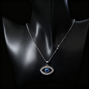 Close-up of Turkish Evil Eye pendant with clear rhinestones on black mannequin