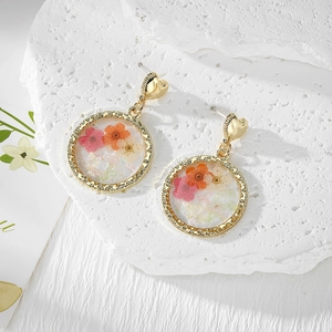 Elegant gold heart earrings with resin round pendants containing real colorful dried flowers