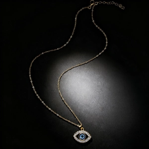 Golden Evil Eye pendant necklace with blue crystals and adjustable chain on black background
