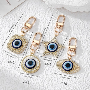 Set of four gold Evil Eye keychains in star, square, and round shapes with dimensions