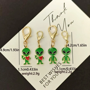 Detail view of green alien enamel charms with heart details and golden lobster clasps