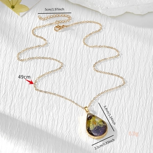 Gold resin necklace with purple and yellow dried flowers and gold leaf pendant