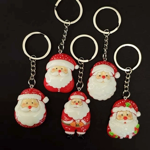 Set of 5 red and white Santa Claus resin keychains with silver metal rings on black background