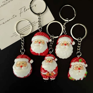 Five-piece Santa Claus keychain set with red and white resin charms on a black background
