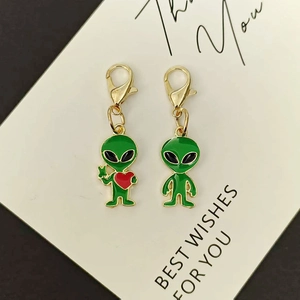 Set of two green alien enamel charms with gold lobster clasp and red heart detail