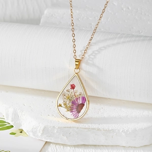 Handmade resin teardrop necklace with real purple and red dried flowers on a gold chain
