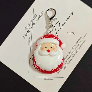 Detail of Santa Claus keychain with lobster clasp on an elegant background card
