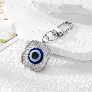 Detail of evil eye keychain with sparkling rhinestones and lobster clasp on stone base