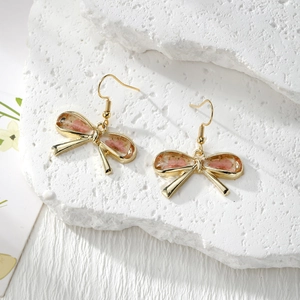 Handmade gold bow earrings with real pink dried flowers in resin on white stone