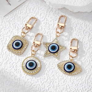 Golden Evil Eye keychains with blue enamel and rhinestones in star and square shapes