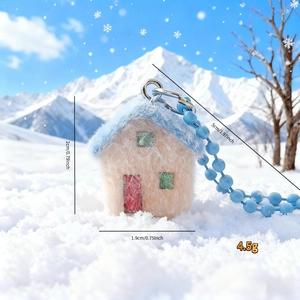 Close-up of a pink snow house plush phone charm with size details and winter backdrop