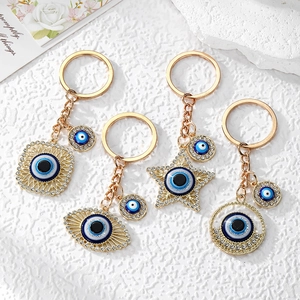 Star and geometric evil eye keychains in gold alloy with blue crystals and sparkling rhinestones