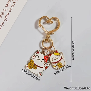 Détail d'un porte-clés chat porte-bonheur avec pendentifs Maneki Neko et gravure