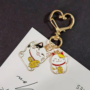 Détails des pendentifs Maneki Neko en émail blanc avec anneau doré en forme de cœur
