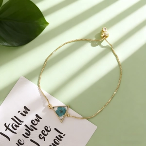 Bracelet doré ajustable avec une véritable fleur séchée bleue dans un pendentif triangle