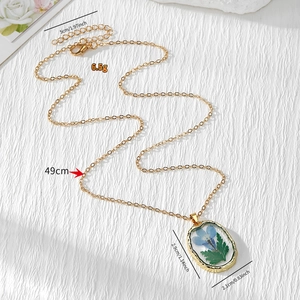 Collier doré avec de vraies fleurs séchées mauves et feuilles vertes en pendentif