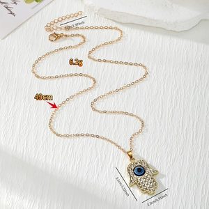 Detailweergave van de Hamsa Hand-hanger met afmetingen en een gouden ketting van 49 cm