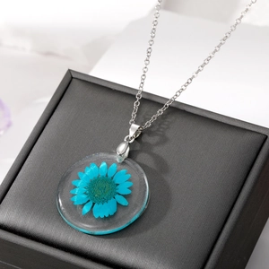 Pendentif rond en résine avec fleur de marguerite bleue séchée et fine chaîne argentée