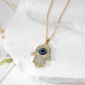Macro-opname van Hamsa Hand hanger met boze oog en strassteentjes op steen