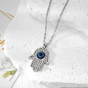 Macroshot van Hamsa Hand-ketting met blauwe Evil Eye en fonkelende kristallen