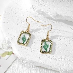 Luxurious gold drop earrings featuring green dried leaves in a vintage rectangle frame