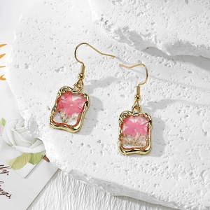 Handmade gold pendant earrings featuring real pink dried flowers in resin frames
