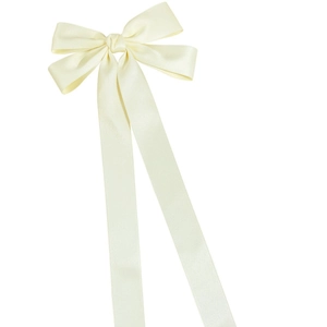 Detail of cream satin bow hair clip featuring long elegant ribbons and silky texture