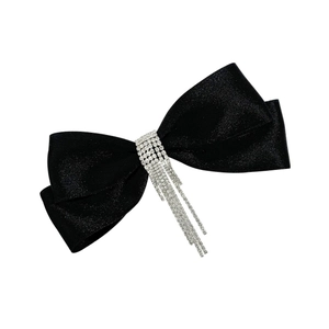 Vue détaillée d'une barrette à cheveux nœud en satin noir avec glands en strass