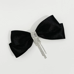 Vue détaillée du nœud en satin noir avec franges scintillantes en strass sur le clip