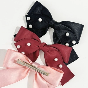 Détail de barrettes à cheveux nœud faites main en satin avec perles nacrées décoratives