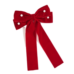 Detailed macro view of red velvet bow hair clip with hand-sewn pearls and long ribbons