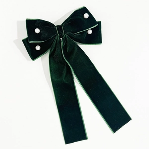 Detail of dark green velvet bow hair clip with elegant handmade pearl embellishments