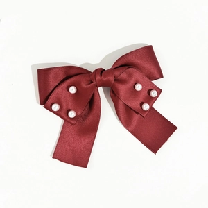 Détail du nœud papillon fait main en satin bordeaux avec d'élégantes perles incrustées