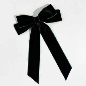Detailed view of the dark green velvet bow hair clip with elegant long ribbons
