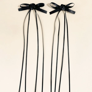 Vista dettagliata di eleganti fermagli per capelli in raso nero con decorazioni a rosa