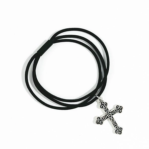 Detail of black multi-strand elastic hair tie with vintage silver cross charm pendant