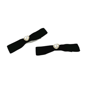 Detailed macro view of black velvet bow hair clips with heart-shaped pearl and rhinestone