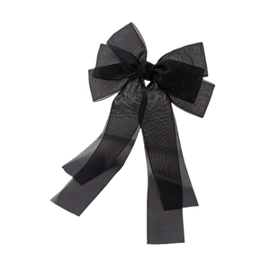 Détail d'une pince à cheveux en organza noir et ruban de satin avec de longs rubans fluides