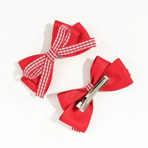 Détail de la barrette en satin rouge avec ruban à carreaux et pince crocodile en métal