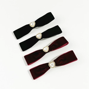 Detail of velvet bow hair clips with heart pearl centers in black and burgundy red