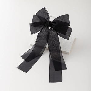 Détail d'un nœud papillon élégant en organza noir avec rubans sur marbre blanc