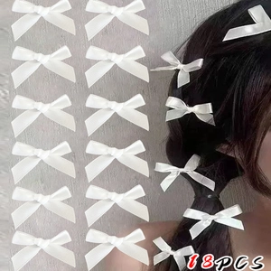 Detailed view of 18 white satin bow hair clips shown on a model for scale and styling