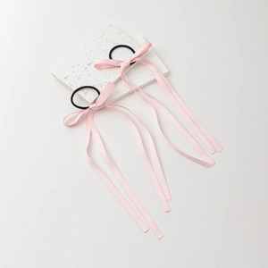 Pink ribbon bow hair ties with long streamers on white stone for balletcore style hair styling