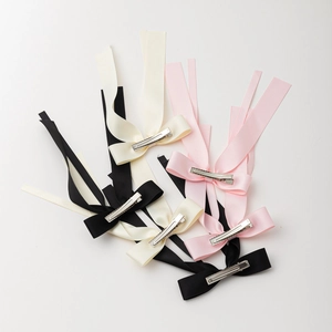 Trois barrettes à nœuds en satin noir, rose clair et ivoire avec de longs rubans fluides