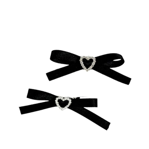 Détail des barrettes nœuds noirs en ruban avec boucle étincelante en forme de cœur