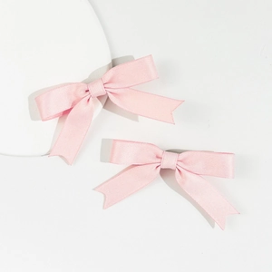 Set of two soft pink satin bow hair clips in minimalist aesthetic for elegant styling