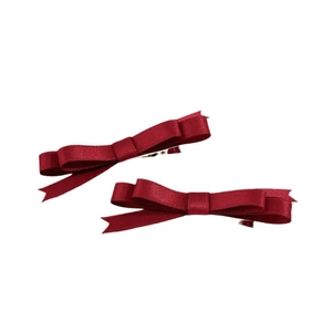 Détail de barrettes à cheveux nœud en satin bordeaux avec texture brillante et clip métal