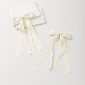 Paire de barrettes à nœuds en satin crème avec de longs rubans au design élégant et épuré